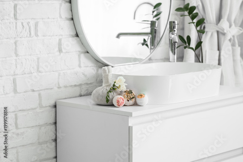 Slika na platnu Floral bath bombs with rose flowers and herbal bag on table near sink in bathroo