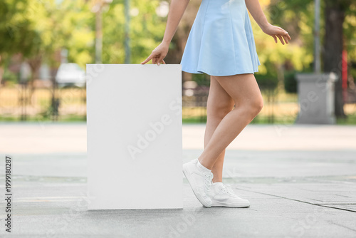Young woman holding blank p...