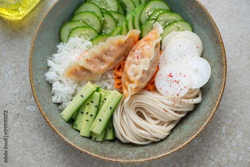 Plate with cucumber, daikon, carrot, noodles and steamed dumplings, horizontal shot, middle close-up