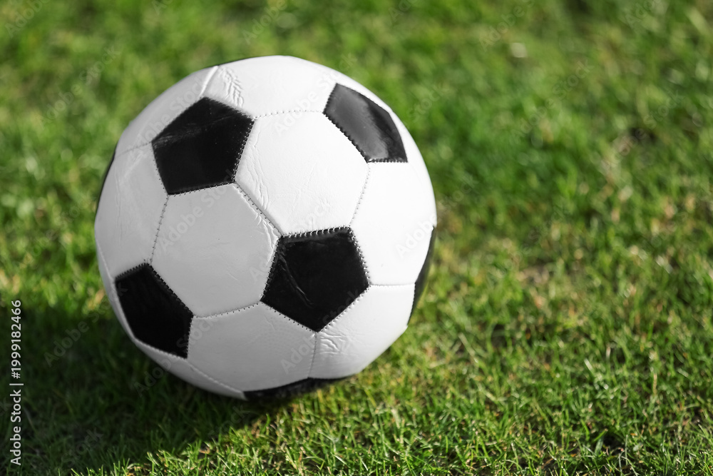Fototapeta premium Soccer ball on green grass, closeup