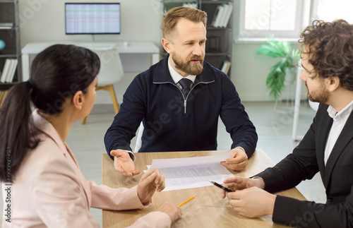 Interview manager and recruiter discuss candidate agreement. Focus on contract review, evaluation, paperwork and hiring decision in office. Concept of hiring and employment agreement.