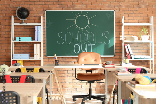Bild auf Leinwand Blackboard with text SCHOOL'S OUT and drawn sun on brick wall in classroom inter