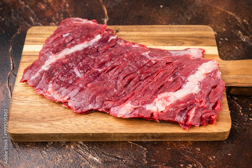 Photography Top view of raw beef bavette flap steak with peppercorn spices and carving fork