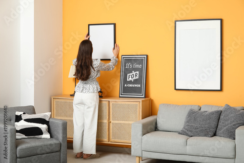 Young woman hanging blank f...