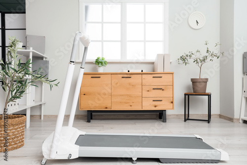 Interior of modern office with treadmill and drawers
