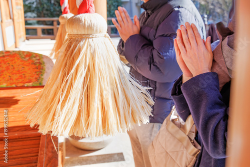 神社の鈴の緒と参拝で手を合わせる人 初詣と合格祈願の祈りの風景