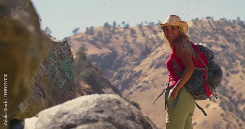 Female Hiker Trekking in Sunlit Mountain Landscape