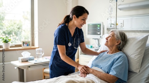 A nurse in blue scrubs with a stethoscope is comforting an elderly patient lying in a hospital bed.