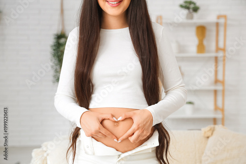 Young pregnant woman making...