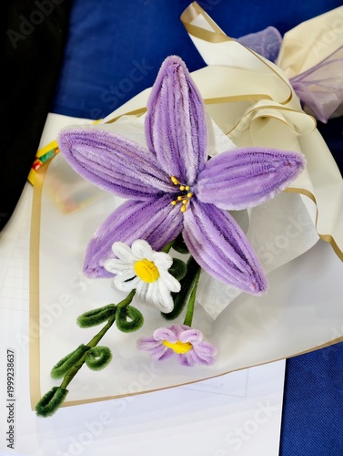 A creative handmade bouquet featuring purple and white flowers made from pipe cleaners. Perfect for graduation congratulations, DIY craft inspiration, and unique celebration gifts.