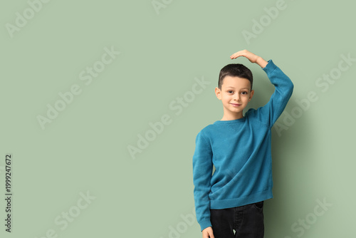 Cute little boy measuring h...