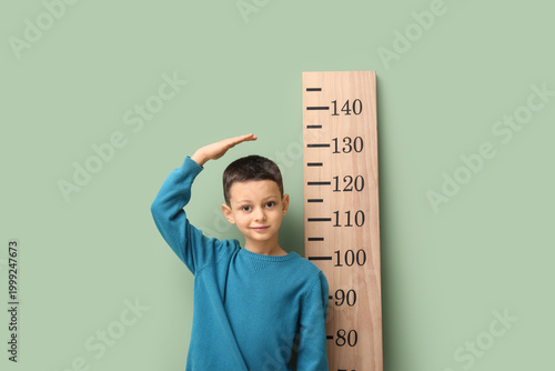 Cute little boy measuring h...