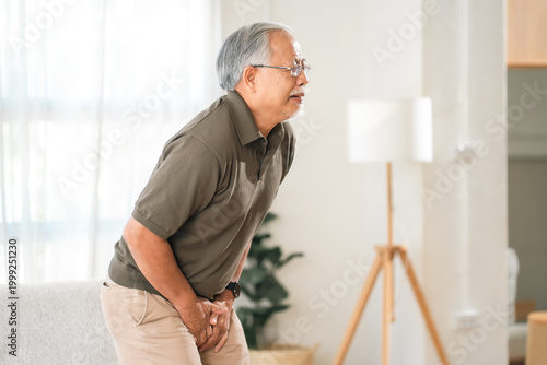 Foto Elderly health insurance, elderly man suffering urinary pain in home interior, s