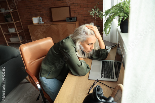 Depressed mature woman sitt...