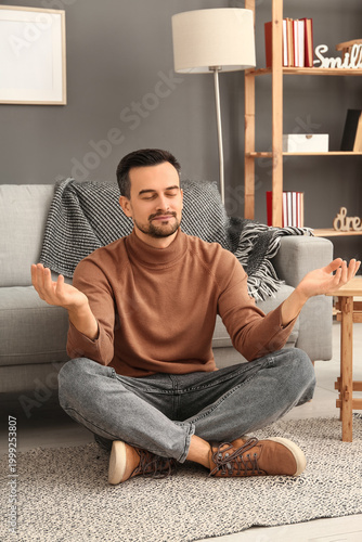 Handsome man meditating on ...