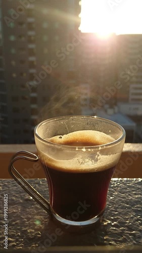都会の朝日を背景にした温かいコーヒー