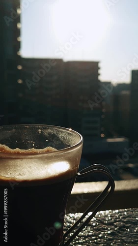 都会のビル群と眩しい朝日を背景にしたコーヒー