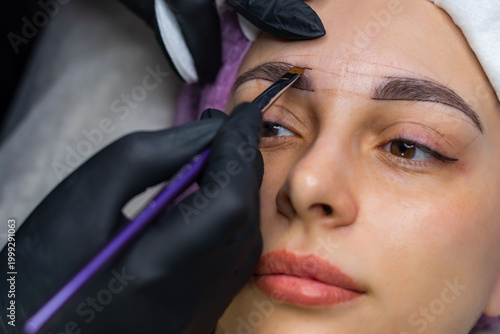 Фотография Close up of eyebrow shaping and mapping before permanent makeup, beautician mark