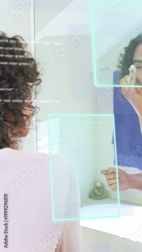 Vertical video: Nonbinary person cleansing at mirror reaching pad, AR overlays tracking skincare