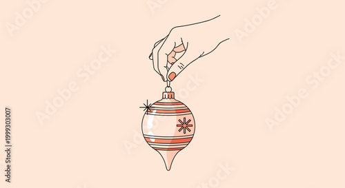 Human hand reaching down to hold a festive striped christmas bauble with a small sparkle for holiday season decorations.
