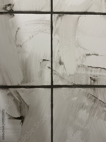 A close-up architectural texture featuring the intersection of dark grey grouted joints between bright white ceramic wall tiles. The tile surface is heavily stained and smeared with wet cement mixture