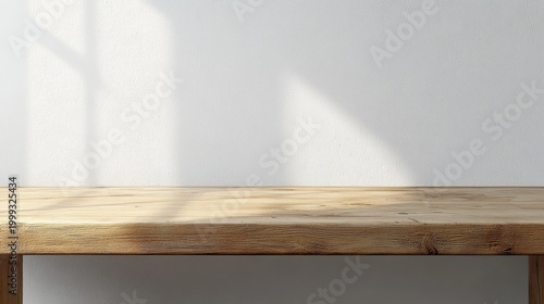 Minimal wooden tabletop against a white textured wall bathed in soft sunlight with gentle window shadows, creating a calm and serene empty interior scene