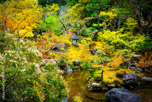 Fotografie Nara, Japan Yoshikien Japanese garden in spring with stone lanterns by pond mapl