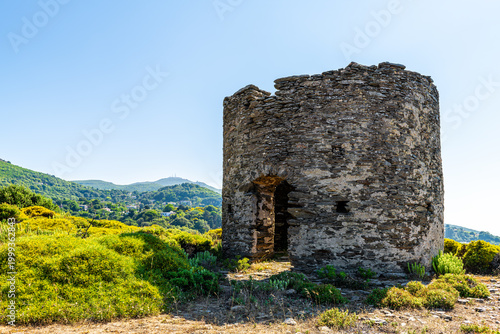 Watchtower military tower ruins at Perdiki village on Ikaria island, Greece cityscape of small town with houses at longevity blue zone