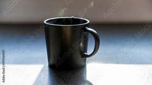 Fotografie One tea or coffee cups with hot drink, steam rising at morning breakfast by wind