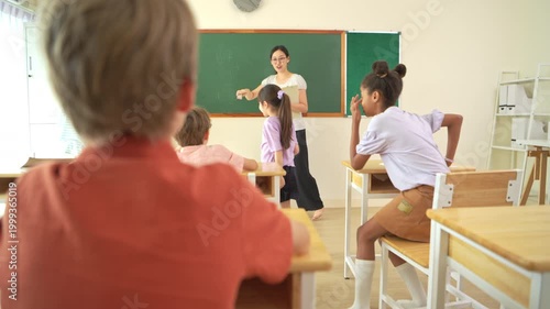 Diverse students writing together on chalkboard in classroom, representing collaborative learning and teamwork