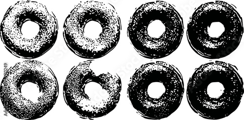 Eight black and white donuts arranged in two rows with one bitten donut in the bottom row