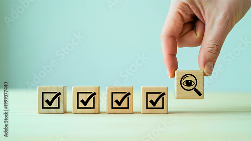 Magnifying glass over a checklist on wooden blocks, symbolizing quality control and thorough examination