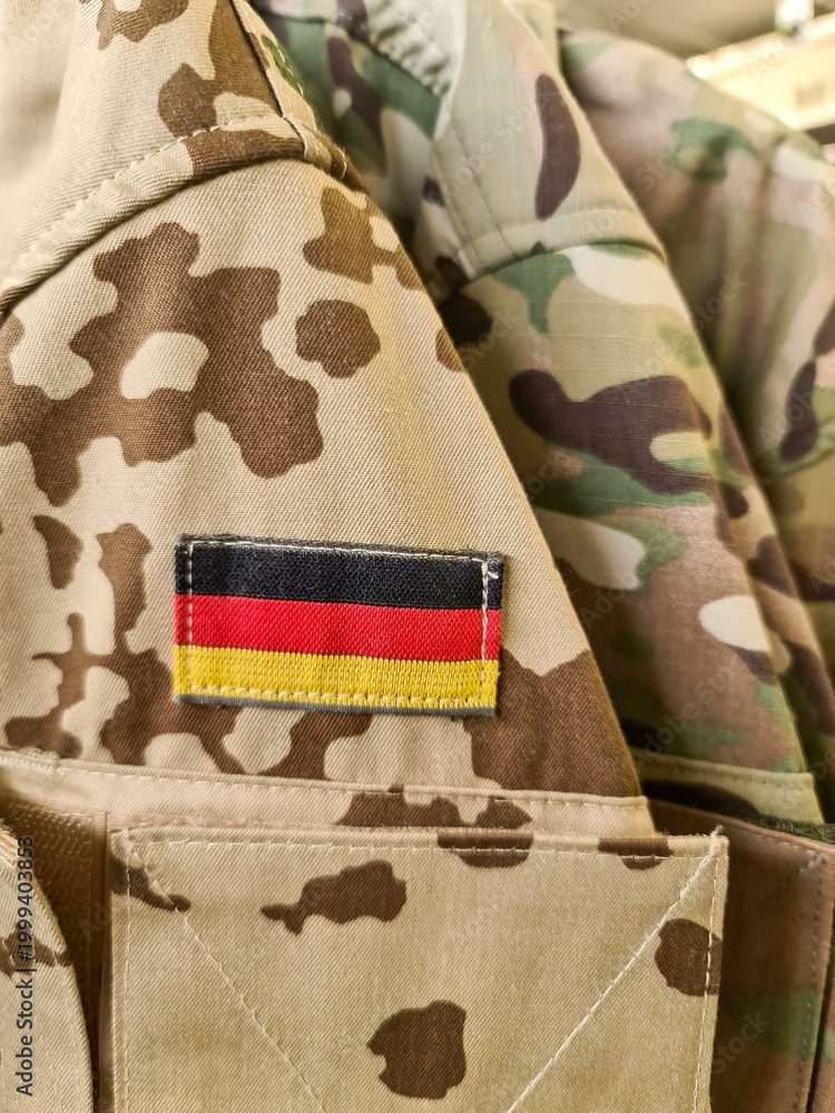 Naklejka premium German flag patch on camouflage military uniform jacket