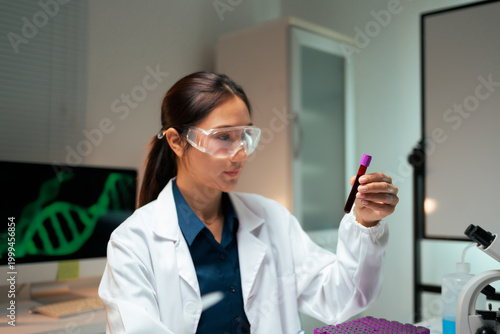Quadro su tela Woman scientist analyzing blood sample in laboratory