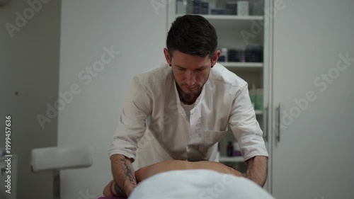 Professional masseur massaging a client's back and shoulders. The tranquil scene takes place in a spa or wellness center