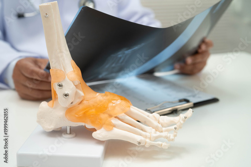 Foto Doctor examining foot ankle  joint bone radiography xray film.