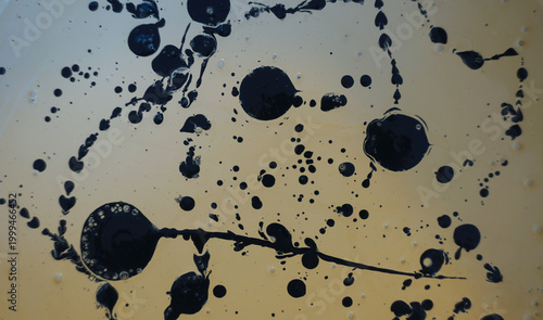 Foto Abstract Background with Black Ink Splashes and Droplets on Light Surface