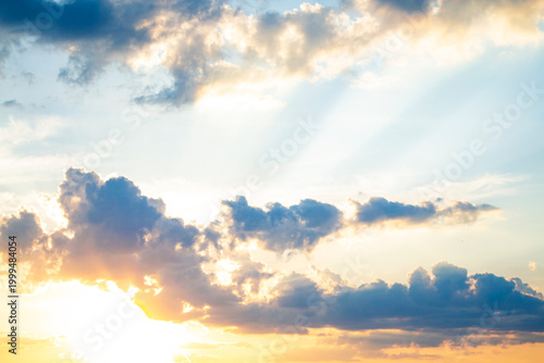 Cumulus clouds. Dramatic orange sky. Abstract nature background. Colorful sky with cumulus clouds and sunbeams.