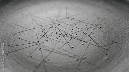 Close-up view of a metallic surface with intersecting lines and dots forming a geometric pattern