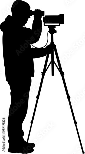 Silhouette of a male photographer using a camera on a tripod