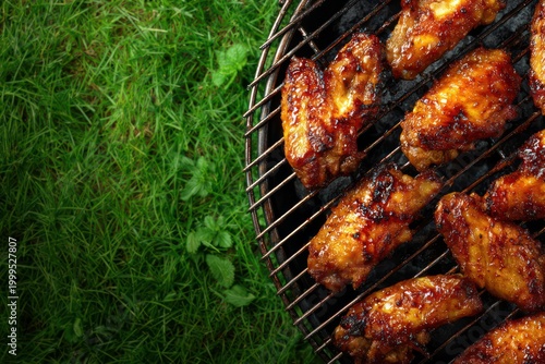 BBQ chicken wings on grill with grass background