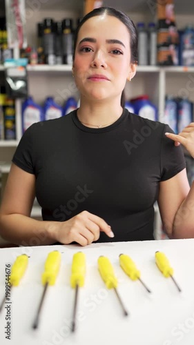 Professional female worker in a hardware store explaining and presenting a set of screwdrivers