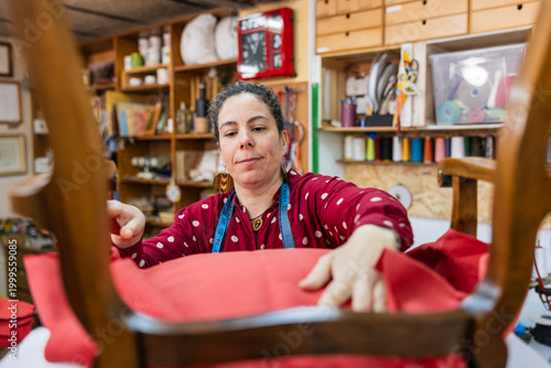 Tableau sur toile Artisan woman restoring chair upholstery in workshop