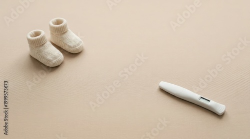 Baby booties and pregnancy test on beige surface symbolizing fertility and anticipation