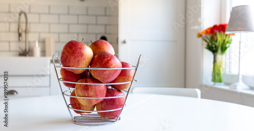 a bowl of fresh red apples on the kitchen table 
