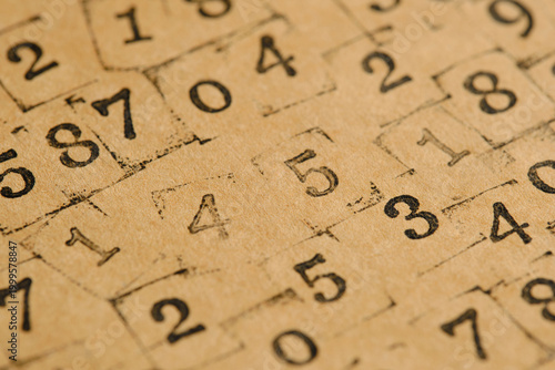 Macro focus on stamped number five with warm light and bokeh effect.