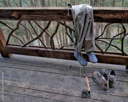 Flyfishing equipment out on a rustic wooden deck and railing
