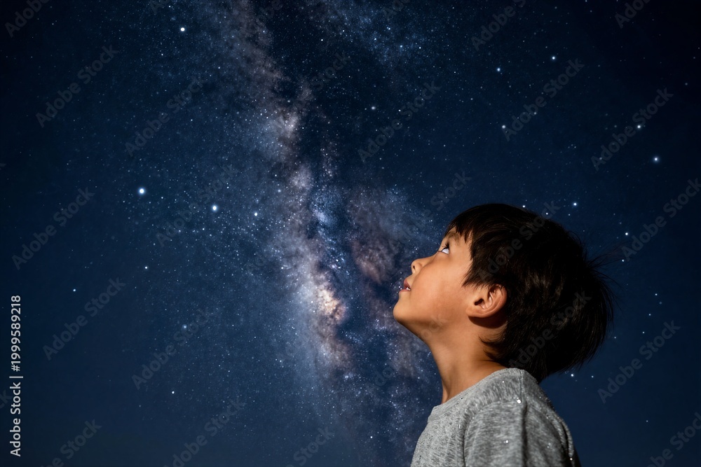 Fototapeta premium Young boy gazing at milky way in clear night sky outdoors