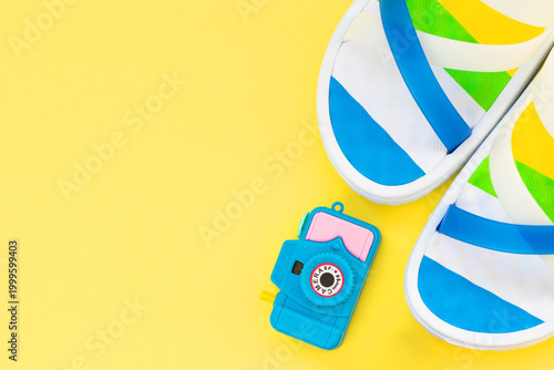 Summer vacation layout with beach accessories and toy camera on yellow