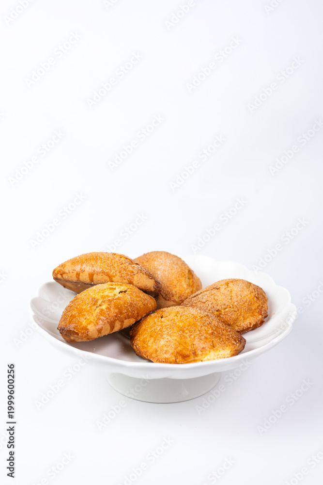 Fototapeta premium Golden cottage cheese pastries sochniki on a white decorative stand.